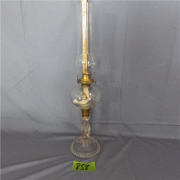 Antique oil lamp featuring a clear molded glass body with a prominent twisted stem often referred to