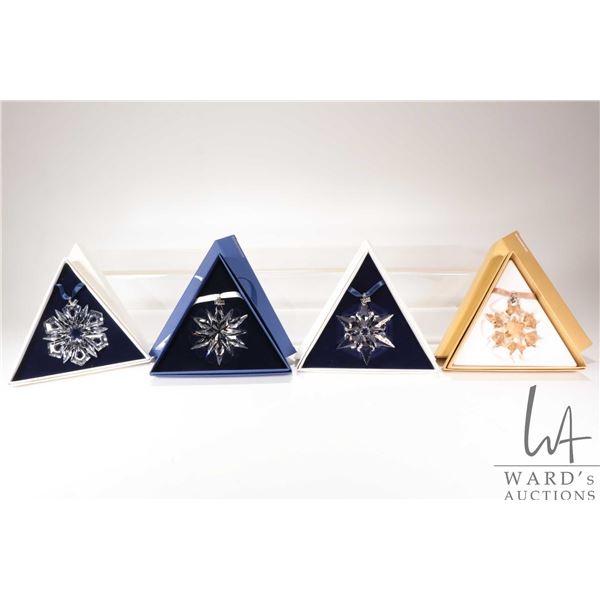 Four Swarovski Crystal collectible snowflakes including 1999, 2000, 2011 20th Anniversary and a 2010