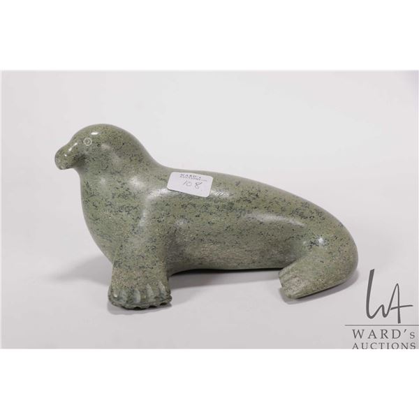 Inuit green soapstone carving of a seal, signed in syllabics and dated 1992, 7" in length