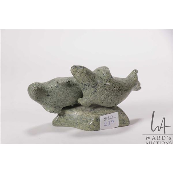 Inuit hand carved, green serpentine soapstone figure featuring two seals, signed by artist in syllab