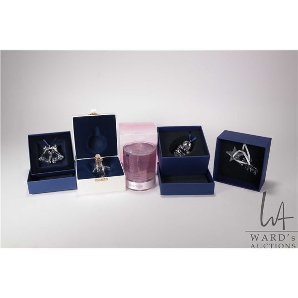 Five Swarovski Crystal collectibles including four Christmas ornaments and a candle