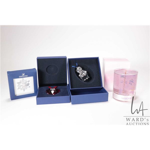 Four Swarovski Crystal collectibles including three Christmas ornaments and a candle