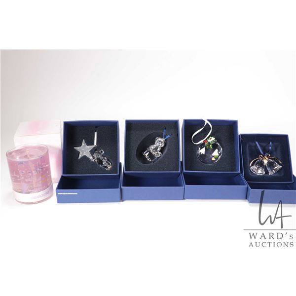 Five Swarovski Crystal collectibles including four Christmas ornaments and a candle