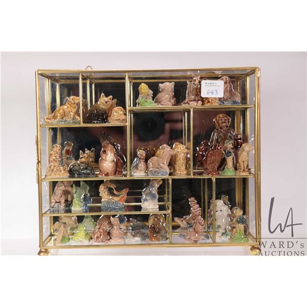 Brass and glass display with thirty five Wade Irish porcelain figures including Nursery Rhyme and an
