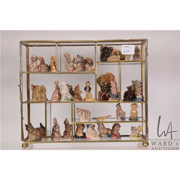 Brass and glass display with thirty six Wade Irish porcelain figurines including Nursery Rhyme and a