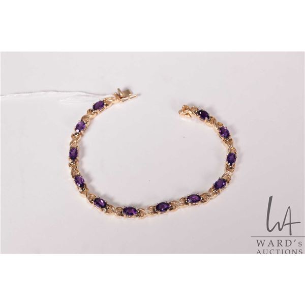 14kt yellow gold X link bracelet set with twelve oval cut amethyst gemstones, 7.5" in length