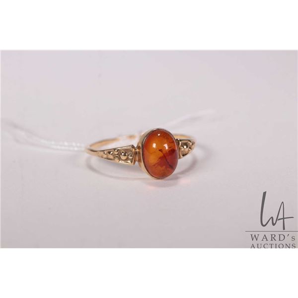 Tested 10kt gold ring set with cabochon amber stone, size 8