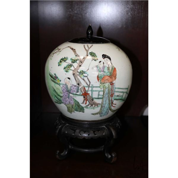 Chinese enameled porcelain ginger jar featuring and domestic garden scene, with black wooden lid and