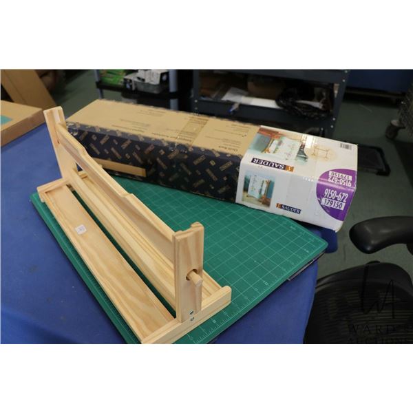 Pine table top paper roll dispenser, a box Sauder wooden quilt rack, a Sew Steady portable table by 