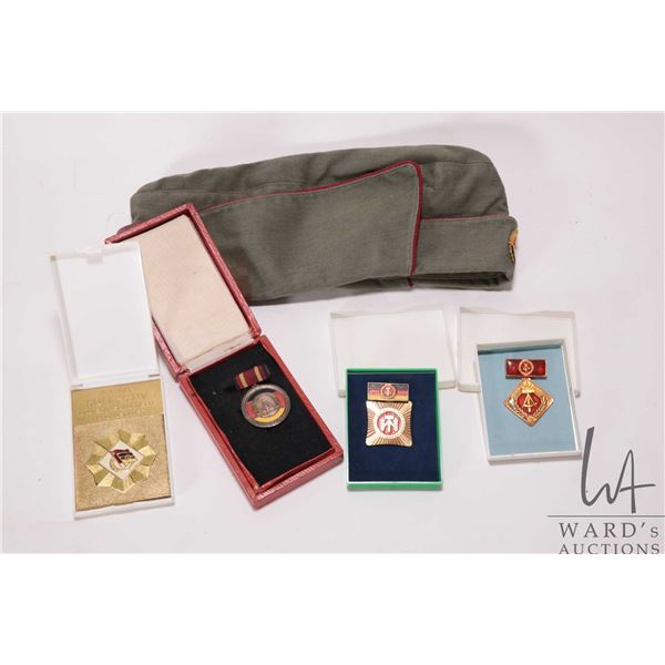 Selection of East German 1950's collectibles including garrison cap with badge, 1959 Merit metal and