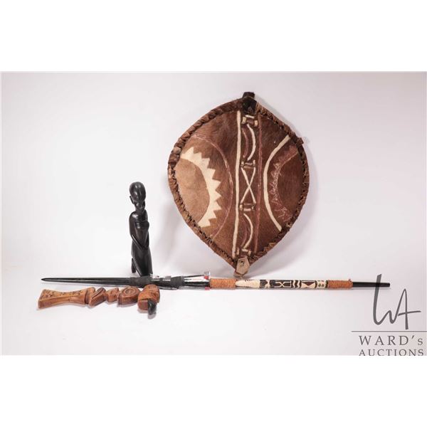 Selection of African collectibles including hide shield, barbed spear, ironwood figure of a woman an