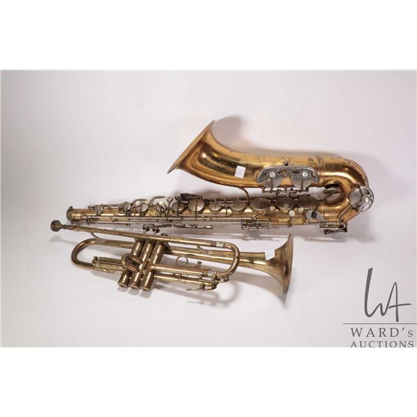 Two brass instruments including a trumpet and a Carl Fisher saxophone, missing mouth piece