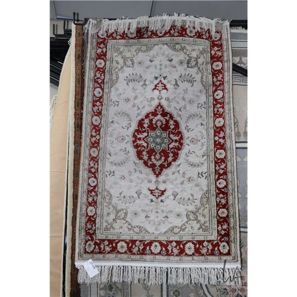 Small scatter rug with center medallion and muted tones, 29" X 48"