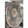 Image 1 : Sculpted oval wool fringed rug with center medallion, deep green background, overall floral design a