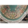 Image 2 : Sculpted oval wool fringed rug with center medallion, deep green background, overall floral design a