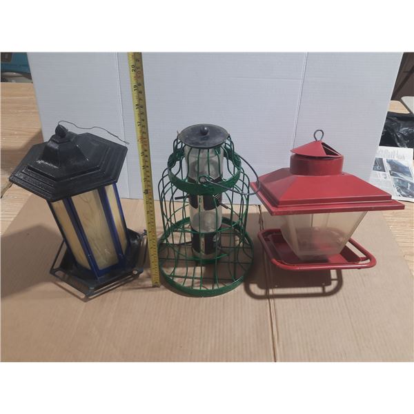 (3) Different hanging bird feeders designed for backyard birding.