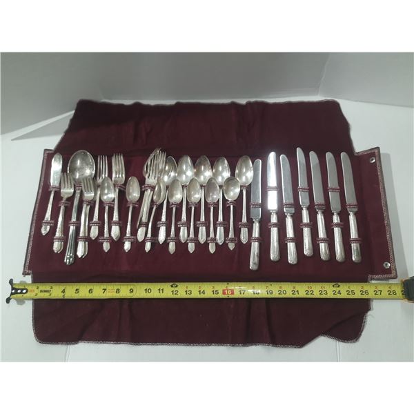 This vintage Wm. Rogers silver-plated flatware set includes various knives, forks, and spoons displa