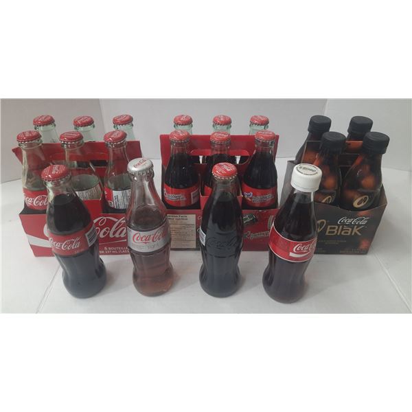 This collection features various Coca-Cola products in traditional glass bottles, including Coca-Col