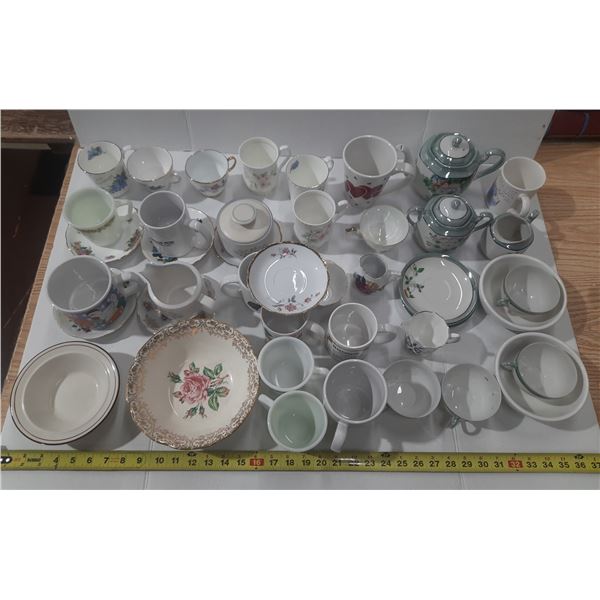 Collection consists of various vintage porcelain items, including teacups, saucers, sugar bowls, and