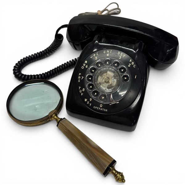 Vintage Black Rotary Dial Telephone Paired with a Brass-framed Magnifying Glass