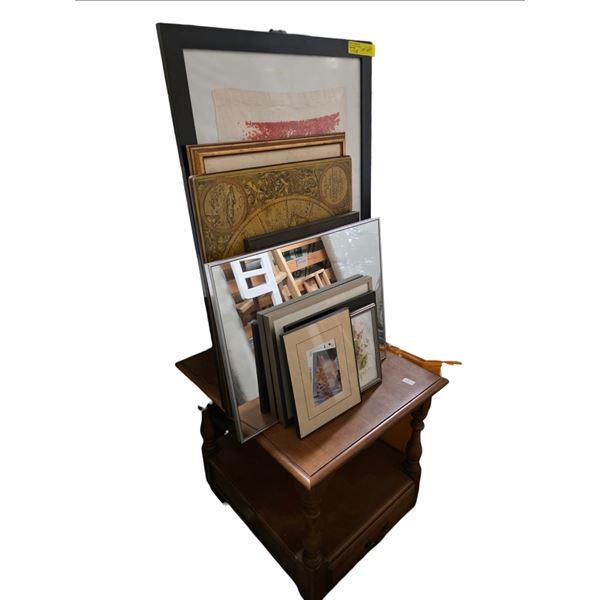 Collection of Assorted Framed Art and Prints Stacked on a Wooden Furniture Piece