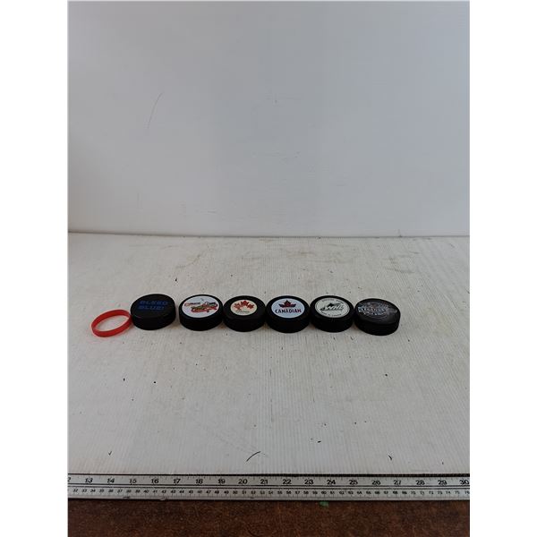 (5) Normal Pucks, (1) Foam Puck with Rubber Wristband As-Is