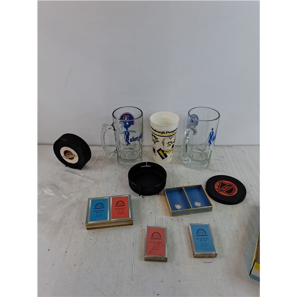 (2) Glass Mugs, (1) Plastic Cup, (2) Hockey Piggy Banks, (2) Sets of Commemorative Playing Cards All