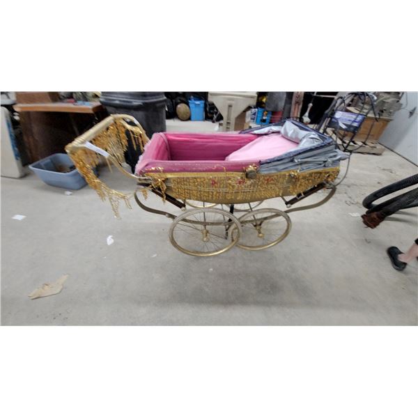 Vintage-Style Ornate Baby Pram with Gold Tinsel Decorations and Pink Interior