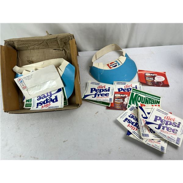 Assorted vintage fountain drink labels and a Pepsi sun visor