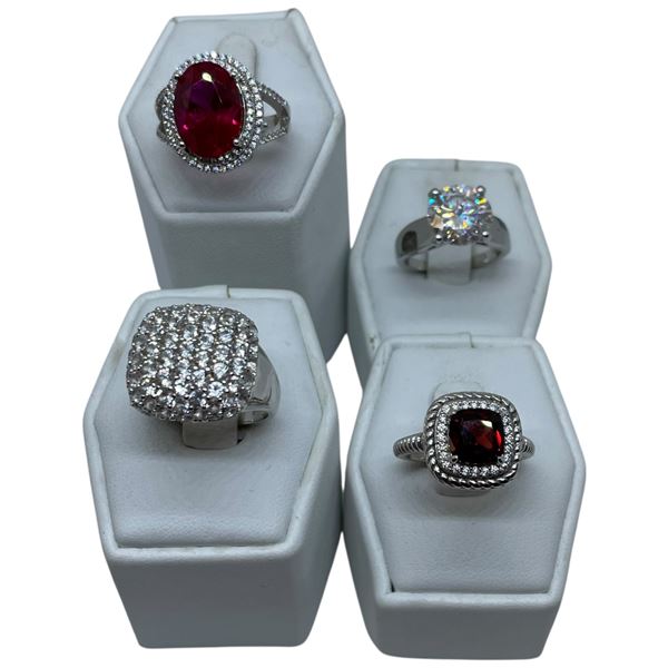4 Rings Stamped .925 (CZ, Clear and Garnet Crystal) Widest ring face is 17 mm * Total weight: 25 gra