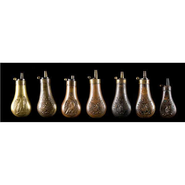 GROUP OF 7 "EAGLE" EMBOSSED POWDER FLASKS.