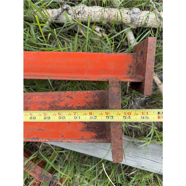  Steel feed stand  I-beams with orange paint, each beam measuring approximately 7 inches in width an