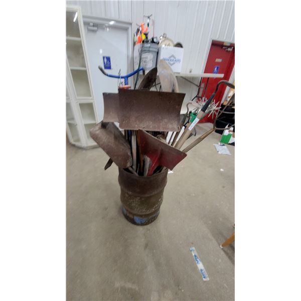 Barrel of Assorted Garden Tools Including Shovels, Hoes, Rakes, Pickaxe, Plow Shares and More