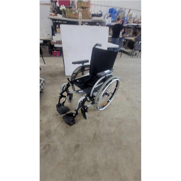 Otto Bock Manual Wheelchair With Silver Frame, Black Seat, and Swing-Away Footrests