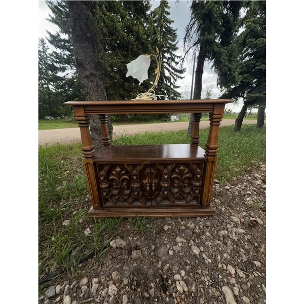 Wood Cabinet With Black Top and Table Lamp