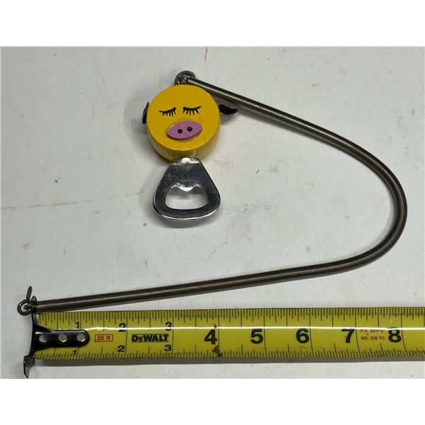 Novelty bottle opener keychain featuring a yellow pig-shaped wooden handle and a retractable metal c