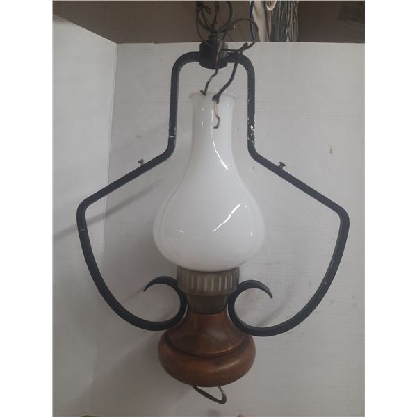 Vintage hurricane hanging lamp features a black wrought iron frame and a white opal glass shade.