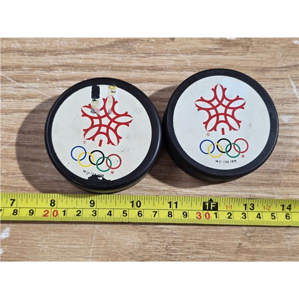 2 olympic hockey pucks