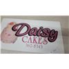 Image 3 : Daisy Cakes Metal Advertising Sign with Three-Tiered Cake Graphic 14”×22”