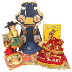 Annie Oakley items (8), includes doll, 2-pc cowgirl outfit w/holster & cap guns, 3-pc Pla-master out