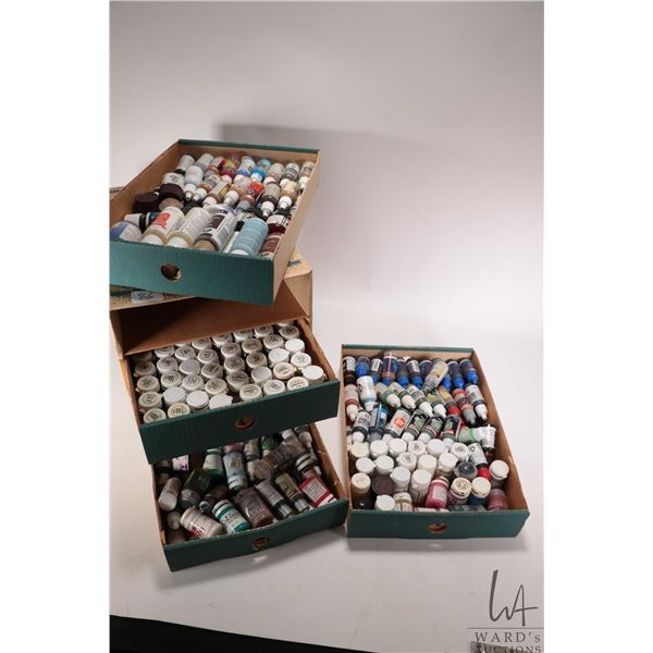 Cardboard four drawer box filled with an assortment of acrylic paints