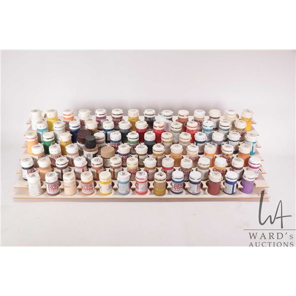 Seven tier paint holder with a large selection of mostly Foundry Paint System acrylic paints, half a