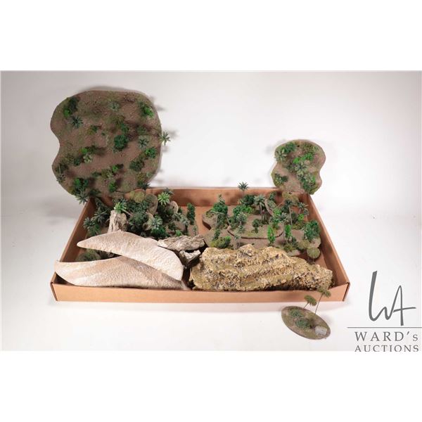 Large selection of tabletop gaming terrain including small forests, rubber rock formations, sandy te