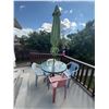 Image 1 : Patio Table With Glass Top, Four Plastic Chairs, and Green Umbrella