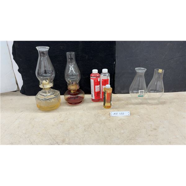 Two Kerosene-Based Lamp Oil Lamps, Three Bottles of Lamp Oil, and Two Lamp Chimneys