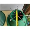 Image 2 : Vintage-style green and red hard plastic Christmas tree stand.