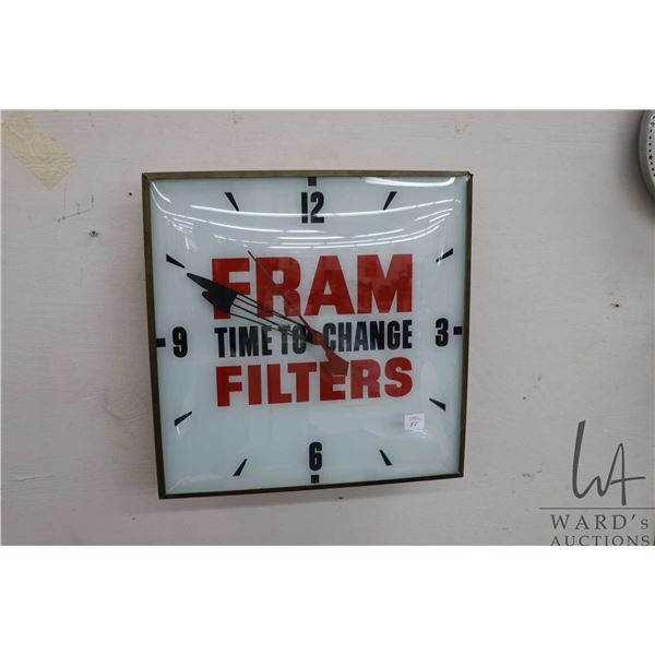 Fram Filters illuminating electric wall clock, 15" square, working at time of cataloguing, needs new