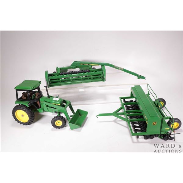 Three Ertl 1:18 scale die cast John Deere toys including 2755 tractor with front end loader, seeder 