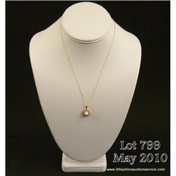 Attractive 14 karat yellow gold ladies pendant set  with a center round pearl averaging 6.50 MM in  