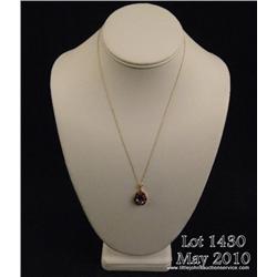 Vibrant 10 karat yellow gold ladies pendant set  with a center pear shape Amethyst weighing approx. 